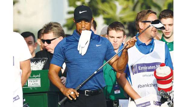 This file photo shows Tiger Woods reacting after playing a shot during the Dubai Desert Classic golf tournament.