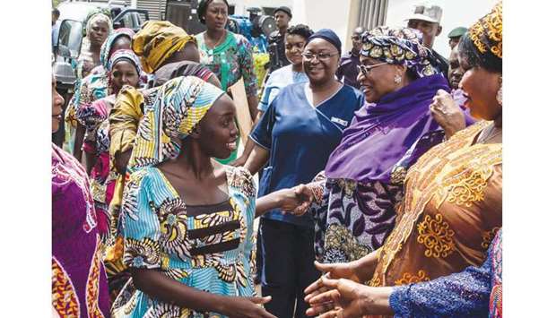 Minister of Women Affairs and Social Development Aisha Alhassan (second right) shakes hands with newly-rescued Chibok school girls upon arrival for rehabilitation at the Women Development Centre in Abuja.