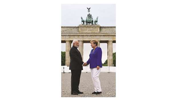 German Chancellor Angela Merkel shakes hands with Prime Minister Narendra Modi in front of the Brandenburg Gate in Berlin yesterday.