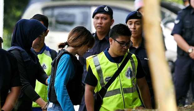 Vietnamese national Doan Thi Huong (centre L, in blue) is escorted by Malaysian police for a court appearance