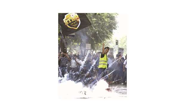 Taxi drivers march as one of their number waves a flag during a strike action held between Atocha train station to Neptuno Square in Madrid.