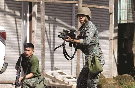 Philippine Marines aim their weapons towards the stronghold of the Maute group in Marawi City, southern Philippines, yesterday.