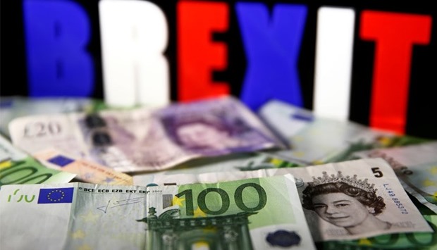 Euro and Pound banknotes are seen in front of BREXIT letters