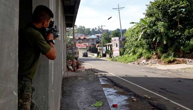 A Philippine Marine fires a weapon towards the stronghold of Maute group in Marawi