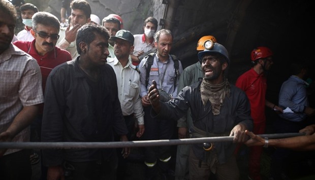 Coal miners and rescue workers gather at the scene following an explosion in a coal mine in Azadshahr, in northern Iran, leaving dozens of miners trapped.