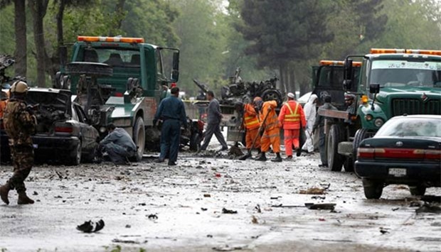 Afghan police and municipal workers clear debris from the site of a suicide bomb attack in Kabul on Wednesday.
