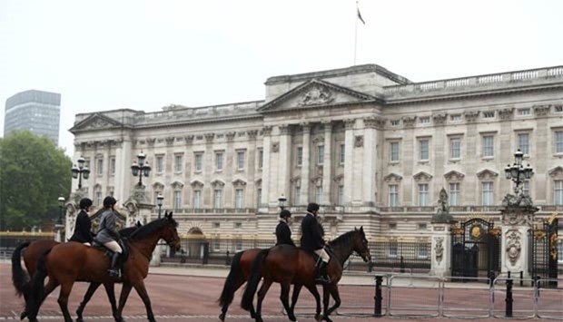 Horses are ridden past Buckingham Palace in London on Thursday.