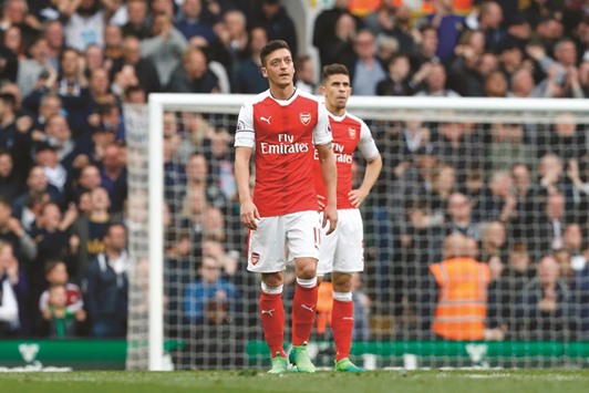 Arsenalu2019s German midfielder Mesut Ozil (L) and Arsenalu2019s Brazilian defender Gabriel react to the first goal by Tottenham Hotspuru2019s English midfielder Dele Alli during the English Premier League match at White Hart Lane in London on April 30, 2017. (AFP)
