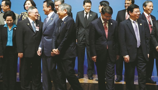 Ministers and central bank governors including Japanese Finance Minister Taro Aso (3rd from left), Bank of Japan governor Haruhiko Kuroda (4th from left), Chinese Vice-Minister of Finance Shi Yaobin (2nd from right) leave from podium after a photo session at Asean+3 finance ministers and central bank governorsu2019 meeting on the sideline of Asian Development Banku2019s annual meeting in Yokohama.