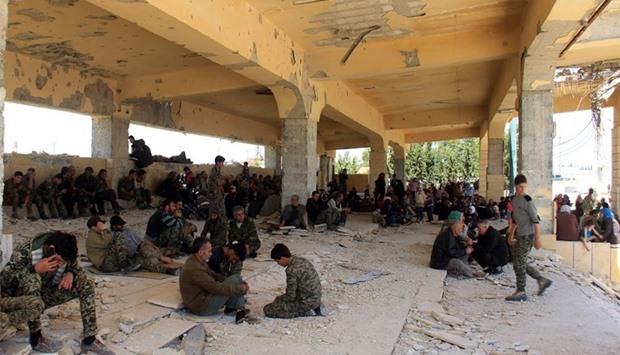 Syrians civilians and pro-government fighters wait for evacuation