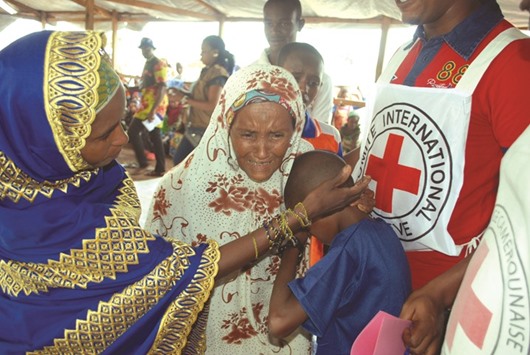 Yaouba Hamadou, a 13-year-old Central African Republic refugee, cries in the arms of relatives in Lolo, east Cameroon, escorted by an International Committee of the Red Cross volunteer. Hamadou has been brought to the camp to be reunited with his sister after having been apart for three years due to the unrest in Central African Republic.