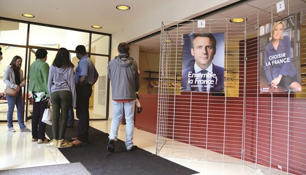 French citizens in the US arrive yesterday to cast their ballots for the French presidential run-off between Macron and Le Pen at the French Embassy in Washington.