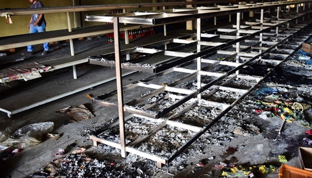 View of damages in a supermarket in Valencia, Carabobo State, on May 5, 2017, the day after anti-government protesters looted stores, set fire to cars and clashed with police.
