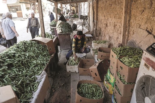 A Syrian man sells vegetables on the street in the rebel-held town of Douma, on the eastern outskirts of Damascus yesterday.