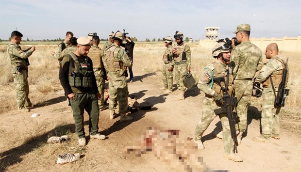 Kurdish peshmerga forces stand near the bodies of suicide bombers of Islamic State, in the city of Kirkuk.
