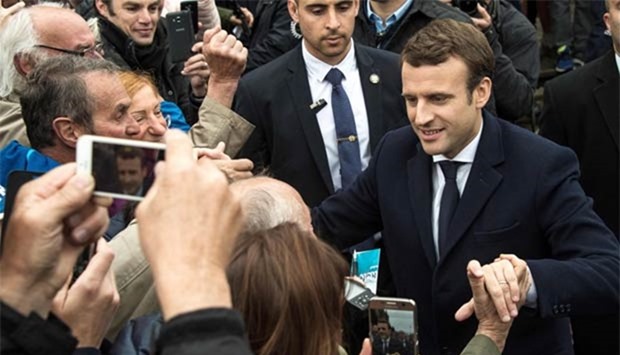 French presidential election candidate Emmanuel Macron shakes hands with supporters in Le Touquet, northern France, on Sunday.