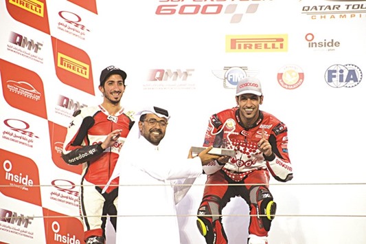 QMMF president Abdulrahman al-Mannai (centre) presents the Race 1 winneru2019s trophy to Saeed al-Sulaiti (right) as Mashel al-Naimi looks on on the podium for the fifth round of Qatar Superstock 600.
