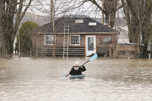 A woman kayaks in a flooded residential area in Rigaud, Quebec.