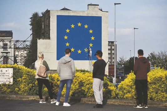 An artwork attributed to street artist Banksy, depicting a workman chipping away at one of the 12 stars on the flag of the European Union, is seen on a wall in the ferry port of Dover, Britain, yesterday.