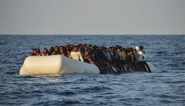 Migrants and refugees on a rubber boat are seen off the Libyan coast in the Mediterranean Sea in this file photo.