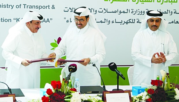 HE the Minister of Transport and Communications Jassim Seif Ahmed al-Sulaiti and HE the Minister of Energy and Industry Dr Mohamed bin Saleh al-Sada exchanging documents of the MoU on `Green car initiative' as Kahramaa president and senior engineer Issa bin Hilal al-Kuwari looks on. PICTURE: Jayaram.
