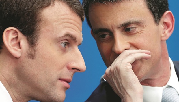 This picture taken on April 8, 2015 shows then-prime minister Valls (right) speaking with then-economy minister Macron at the Elysee Palace in Paris. Valls said yesterday that he wanted to stand for President-elect Macronu2019s political movement in June parliamentary elections, the first high-profile defection since Macronu2019s election win.