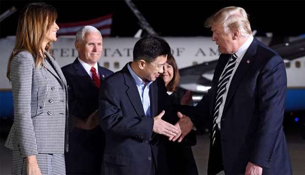 US President Donald Trump (R) shakes hands with US detainee Tony Kim (C) as US Vice President Mike Pence (back L) and Melania Trump (L) look on