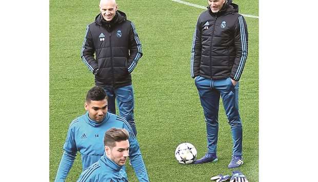 Real Madridu2019s coach Zinedine Zidane (right) looks on at midfielder Casemiro and goalkeeper Luca Zidane Fernandez (foreground) during a training session in Madrid yesterday. (AFP)