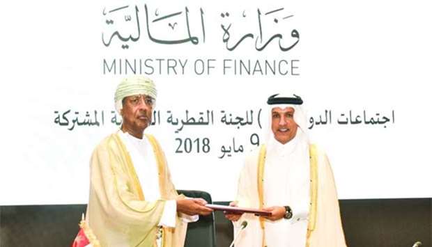 HE al-Emadi and al-Balushi exchange documents after concluding an agreement during the 19th session of the Qatari-Omani Joint Committee.
