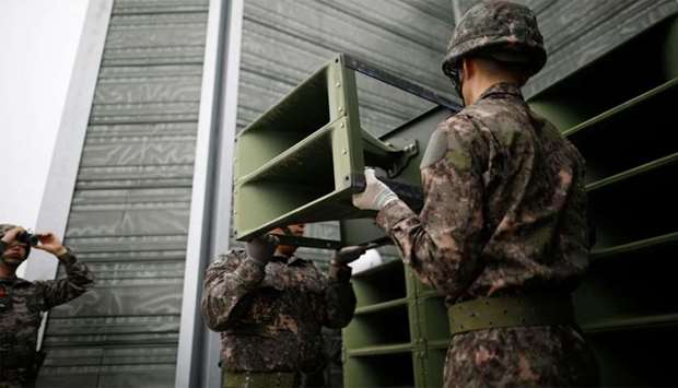 South Korean soldiers dismantle loudspeakers that were set up for propaganda broadcasts