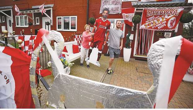 Liverpool Football Club supporters Emily and David Farley carry a cardboard cut out of Liverpool player Mohamed Salah outside their house which has been decorated ahead of the clubu2019s Champions League final appearance against Real Madrid, in Liverpool. (Reuters)