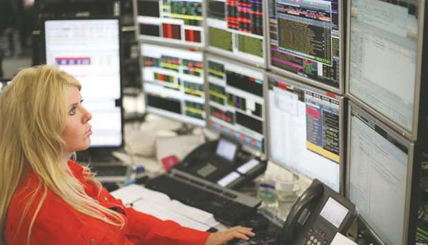 A trader monitors share prices at the London Stock Exchange. The FTSE 100 gained 0.9% to 7,509.30 points yesterday.