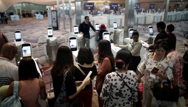 Passengers line-up at automated immigration control gates at Changi airport's Terminal 4 in Singapore