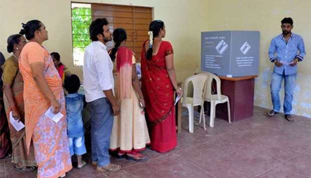 Indian voters queue to cast their ballots in the Karnataka assembly elections at a polling station in Bengaluru on Saturday.