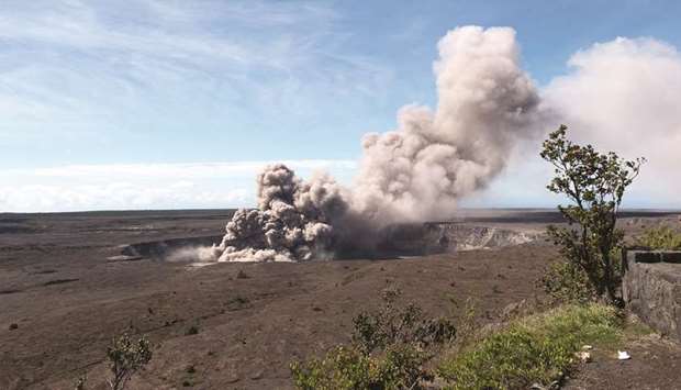 An ash plume rises from the Overlook Vent in Halemau2019umau2019u crater in Hawaii.
