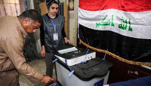 An Iraqi voter dips his finger in ink before casting his ballot at a poll station in the capital Baghdad