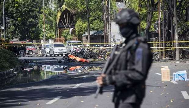 An Indonesian anti-terror policeman stands guard at the blast site following a suicide bomb outside a church in Surabaya on Sunday.