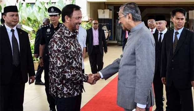 Prime Minister Mahathir Mohamad shaking hands with Brunei's Sultan Hassanal Bolkiah upon his visit to the Perdana Leadership Foundation in Putrajaya on Monday.