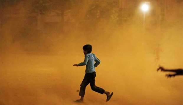A boy runs for cover during a dust storm in New Delhi on Sunday.