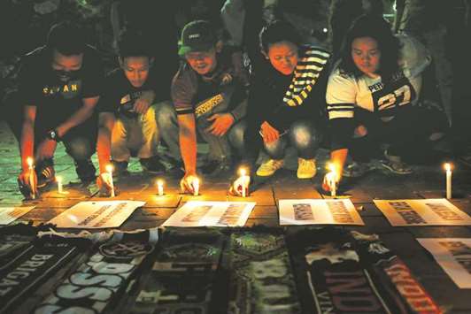 Football supporters from East Java hold a vigil for victims of the suicide bomb attacks in Surabaya at a city park in Jakarta, Indonesia.