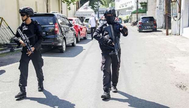 Mobile brigade police patrol around the Surabaya police headquarters following a suicide attack in Surabaya on Monday.