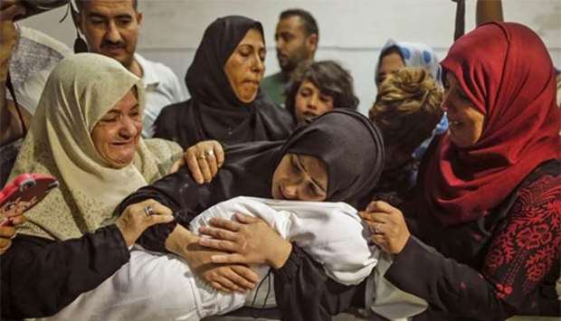 The mother of a Leila al-Ghandour, an eight-month-old Palestinian baby who according to the Palestinian health ministry died of tear gas inhalation during clashes in East Gaza the previous day, holds her at the morgue of al-Shifa hospital in Gaza City on Tuesday.
