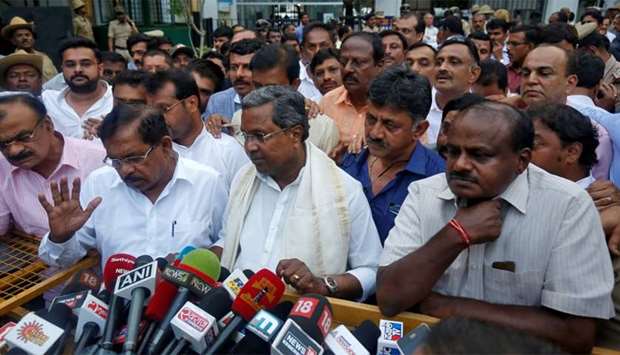Outgoing Chief Minister of the southern state of Karnataka Siddaramaiah and Janata Dal (Secular) leader Kumaraswamy speak with the media outside the governor's house in Bengaluru