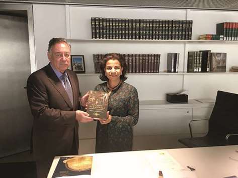 GIFT: The Portuguese ambassador, left, donating a book to QNL executive director.
