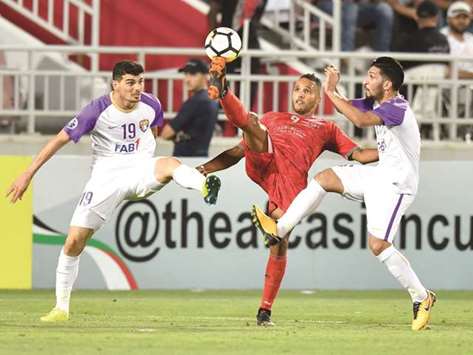 Al Duhailu2019s Youssef El Arabi (centre) vies for the ball with Al Ain players during the second leg of their AFC Champions League Round of 16 tie. PICTURE: Noushad Thekkayil