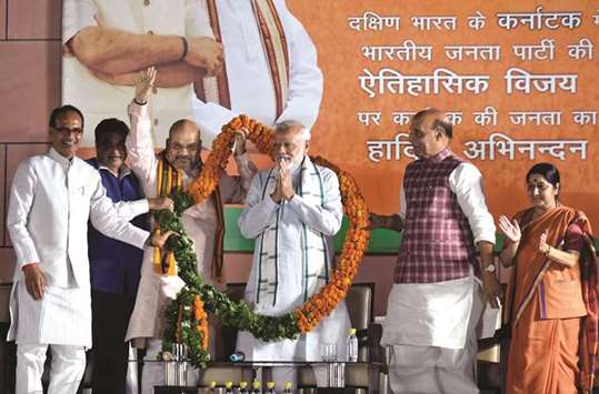 Prime Minister Narendra Modi is presented a garland as Madhya Pradesh Chief Minister Shivraj Singh Chouhan, Transport Minister Nitin Gadkari, Bharatiya Janata Party president Amit Shah, Home Minister Rajnath Singh and Foreign Minister Sushma Swaraj look on during a ceremony after the Karnataka election at its party headquarters in New Delhi yesterday.