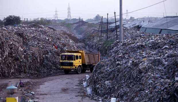 Smoke billows as a truck drives past the waste of leather tanneries at a dumpyard in Kanpur