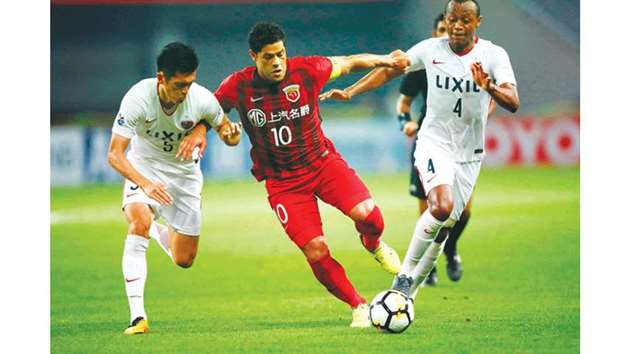 Shanghai SIPGu2019s Hulk (centre) vies for the ball with Kashima Antlersu2019 Leo Silva (right) and Ueda Naomichi during the AFC Champions League round of 16 match. (AFP)