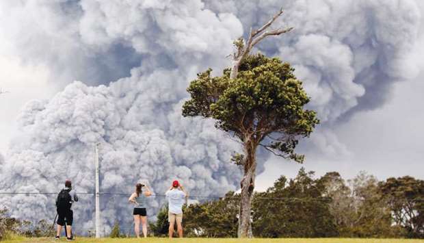 People watch as ash erupts from the Halemaumau crater near the community of Volcano during ongoing eruptions of the Kilauea Volcano in Hawaii on Tuesday.