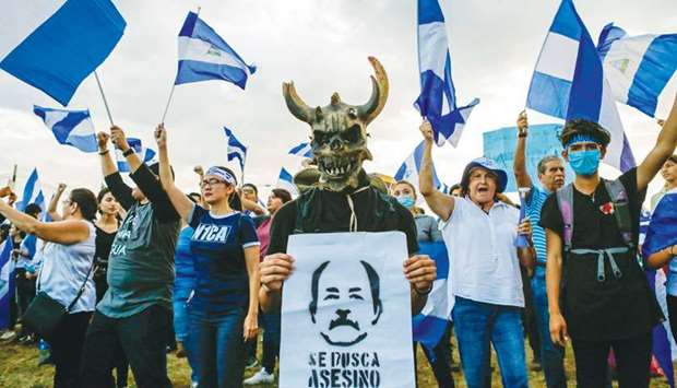 A student holds a sign depicting Nicaraguan President Daniel Ortega and reading u2018Assassin Wantedu2019 during a protest in Managua on Tuesday.